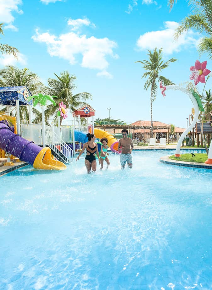 Uma família feliz, composta por pai, mãe e filha, está se divertindo ao máximo na piscina do Salinas Maragogi, um incrível resort da Amarante no paraíso de Alagoas. Com sorrisos radiantes, eles aproveitam o sol e a água cristalina, criando memórias inesquecíveis juntos.