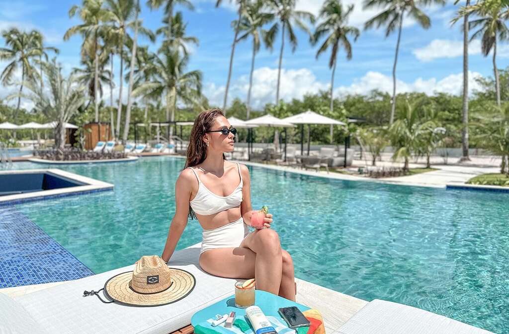 mulher perto de piscina de resort após aproveitar o Tô de Volta Amarante
