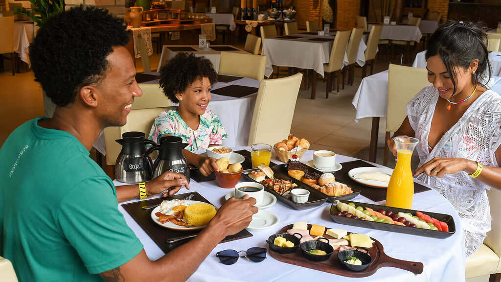 família almoçando em restaurante representando o que é um resort all inclusive