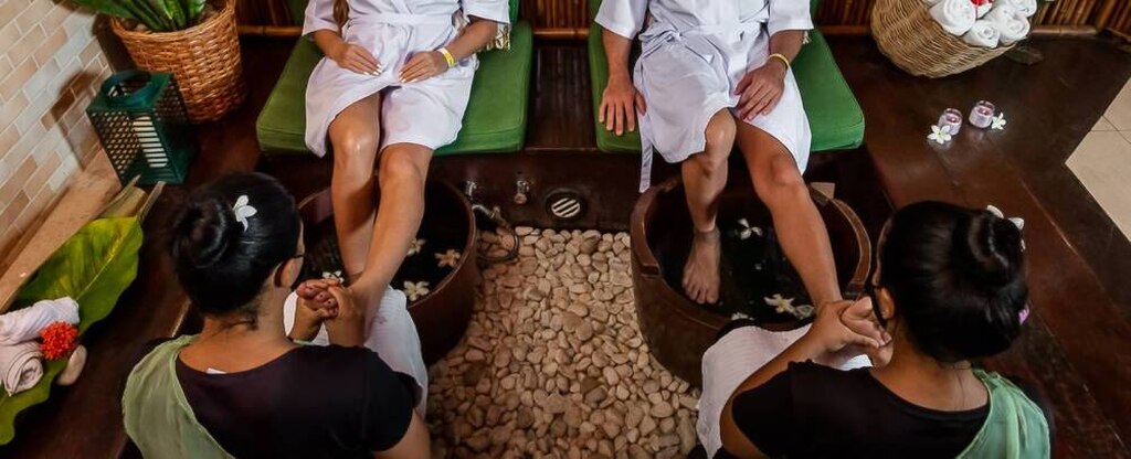Casal relaxa enquanto recebe uma massagem nos pés em um spa aconchegante.