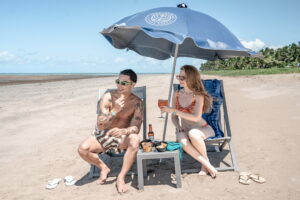 Casal aproveitando All Inclusive Premium do Japaratinga Lounge Resort na praia em dia ensolarado