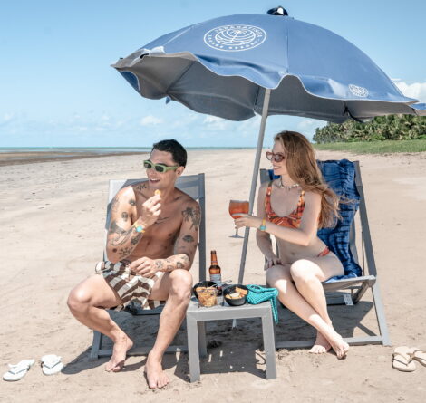 Casal aproveitando All Inclusive Premium do Japaratinga Lounge Resort na praia em dia ensolarado