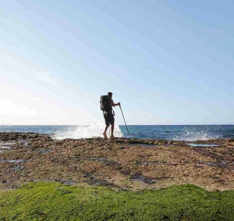 Viajante fazendo trilha ecológica perto da praia.