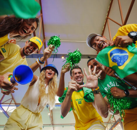 Torcida animada em volta da câmera no Salinas Maragogi com roupas verde e amarelo e com acessórios comemorando hexa do brasil