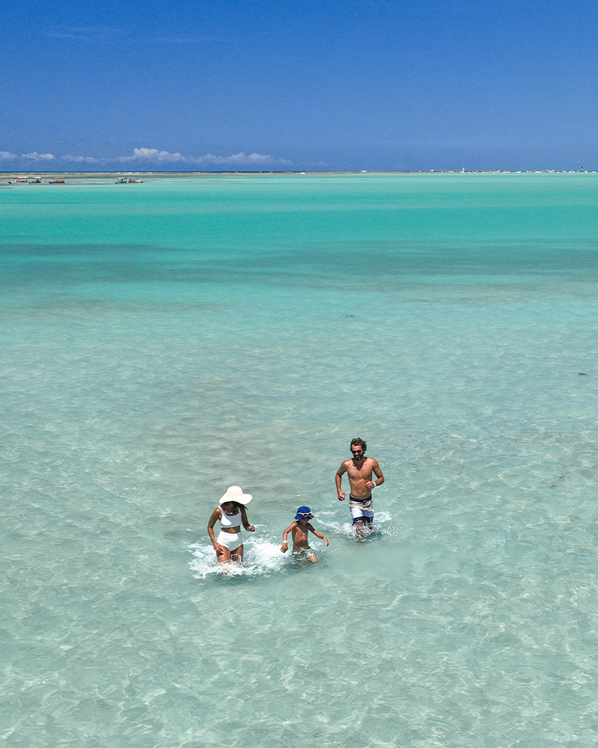 Um marzão de lembranças na Praia de Xaréu Família aproveitando as piscinas naturais da Praia de Xaréu durante passeio com águas azuis e cristalinas.