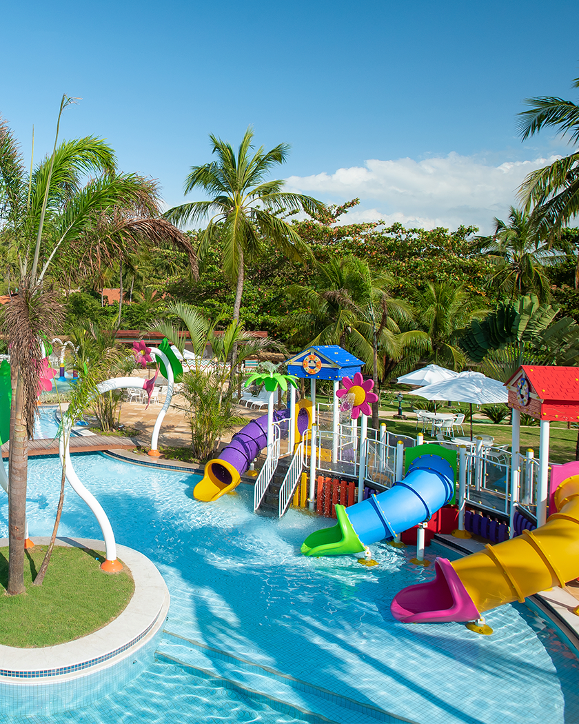 Diversão pra todas as idades Área infantil aquática do Salinas Maragogi com brinquedos pra crianças e cercados por coqueiros.
