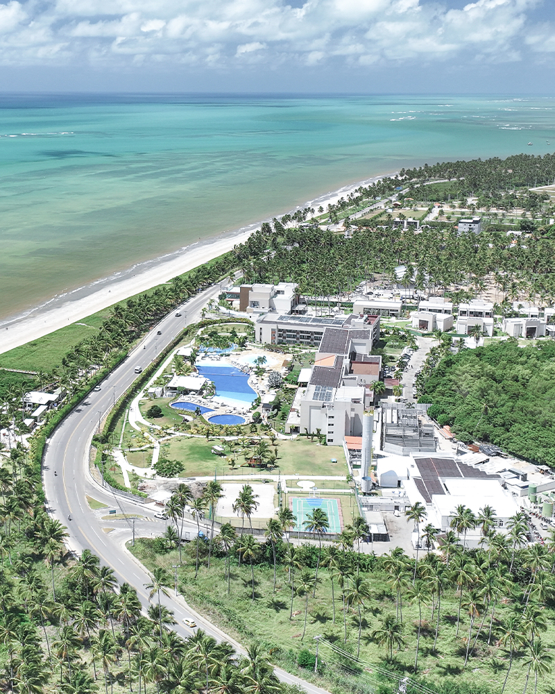 O paraíso conhecido como Japaratinga Lounge Resort Vista aérea do Japaratinga Lounge Resort, com suas acomodações, diversos pontos de consumo e complexo de piscinas, rodeado por uma densa vegetação nativa e à beira mar.